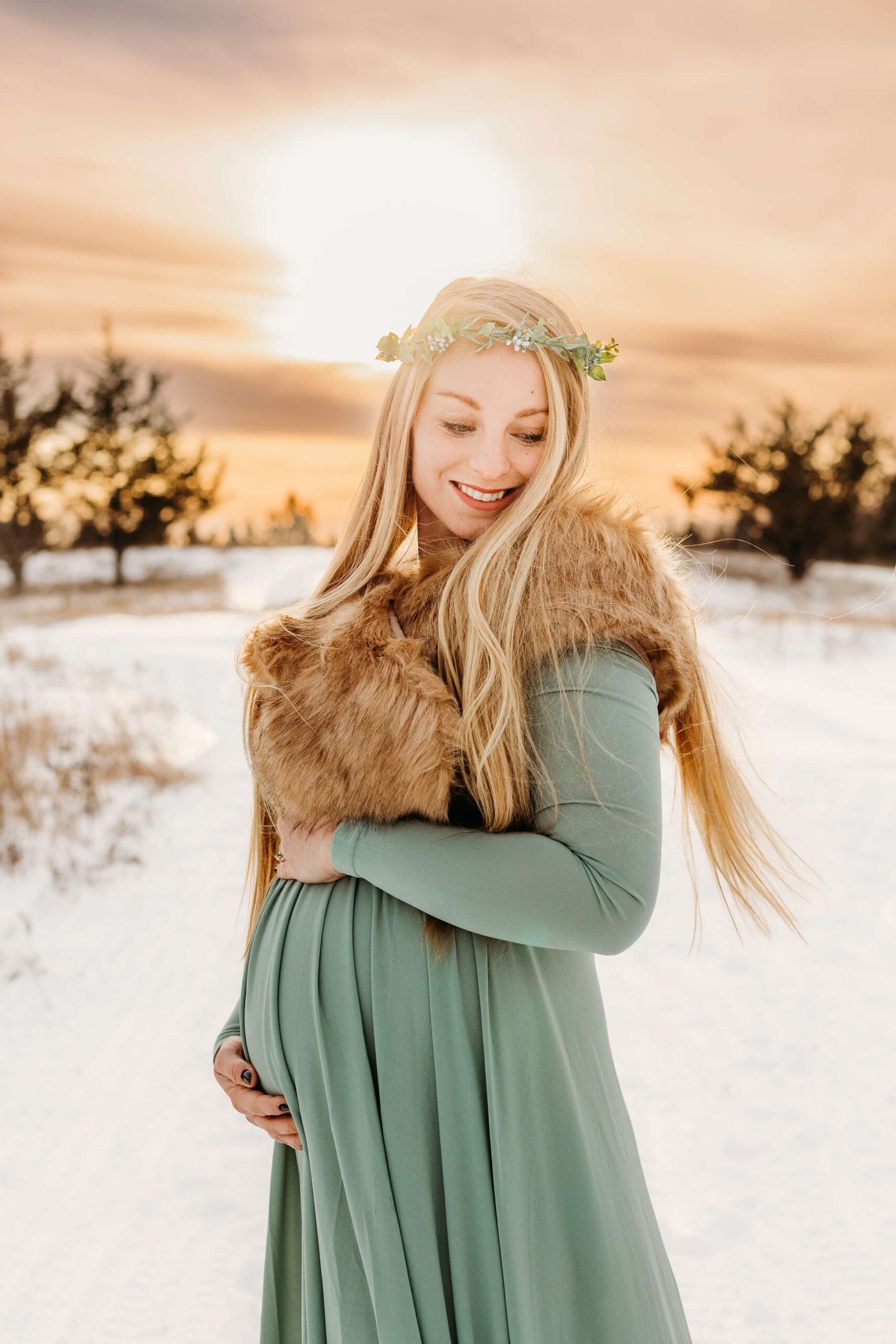 mom to be in sage maternity gown in the snow Eau Claire Massage
