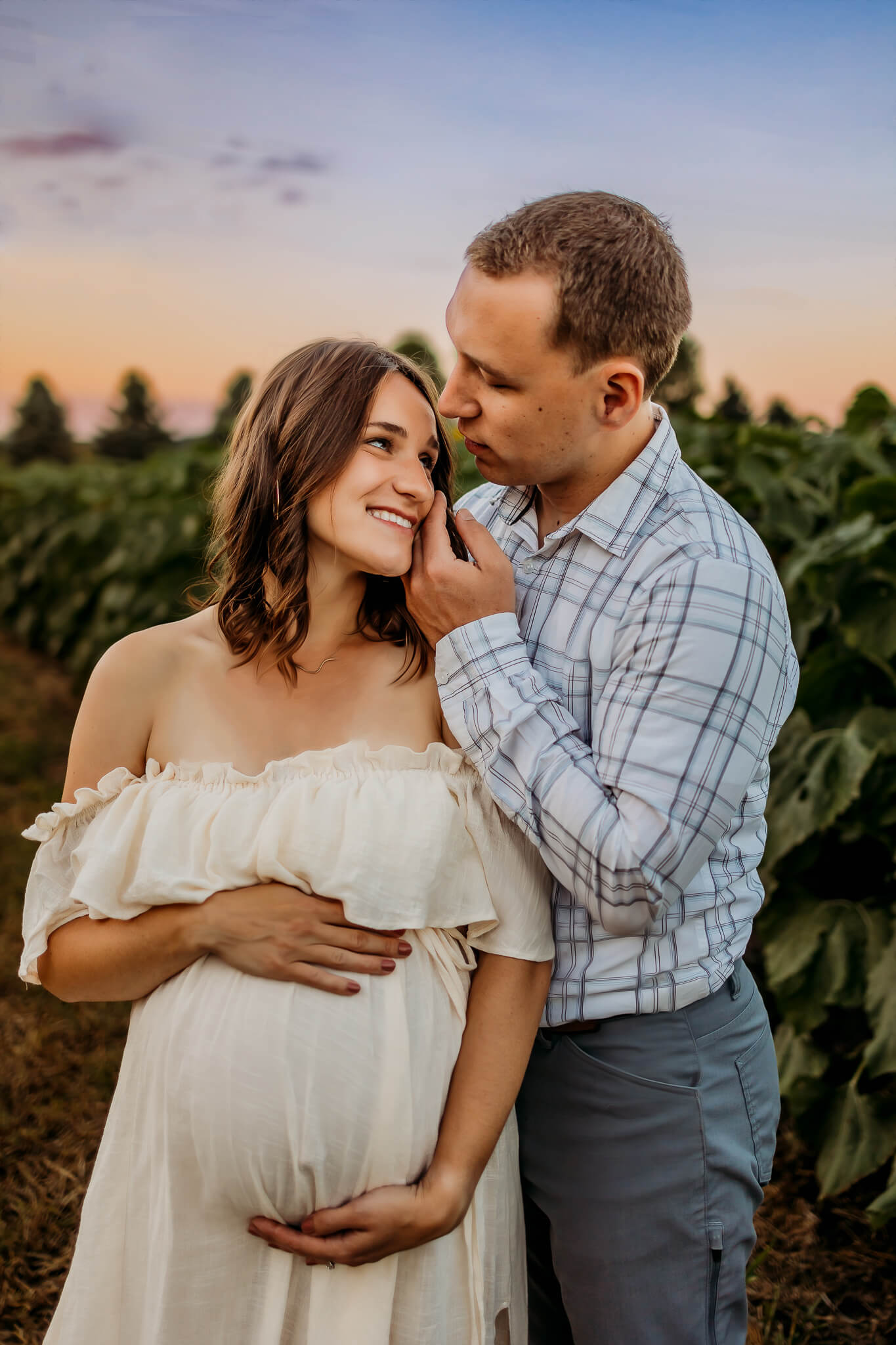 Expecting parents share a happy moment in a sunflower farm